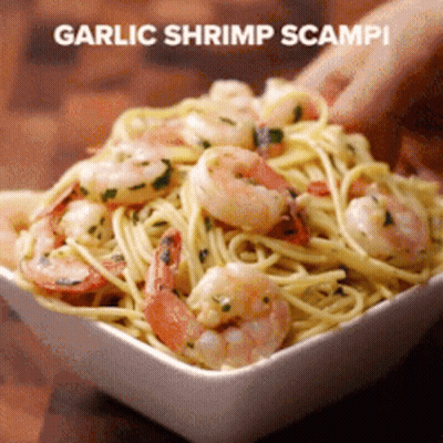 A Person Is Holding A Bowl Of Garlic Shrimp Scampi Pasta GIF