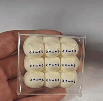 A Person Is Holding A Box Of White Marshmallows With Cats On Them GIF