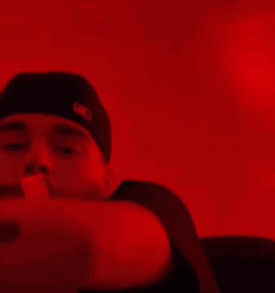 A Person Is Holding A Bunch Of Money In Their Hands In A Red Light . GIF