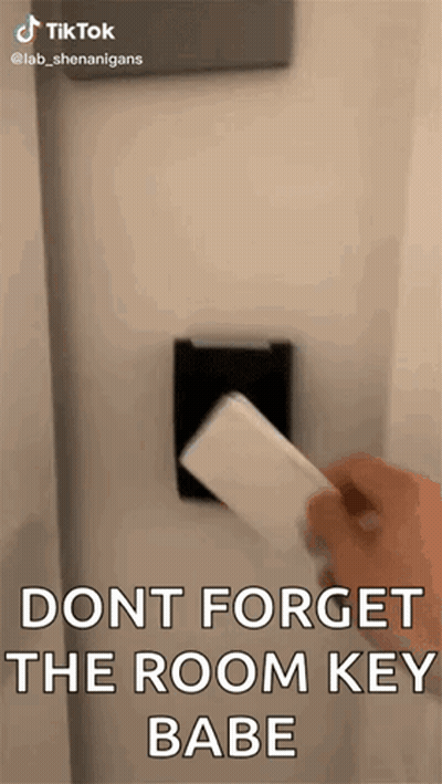 A Person Is Holding A Card In Front Of A Door . GIF