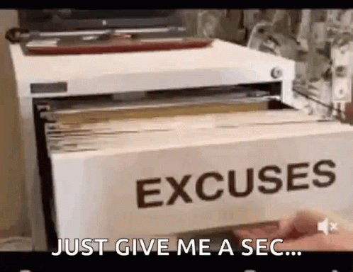 A Person Is Holding A Card That Says `` Just Give Me A Sec ... '' In Front Of A File Cabinet . GIF