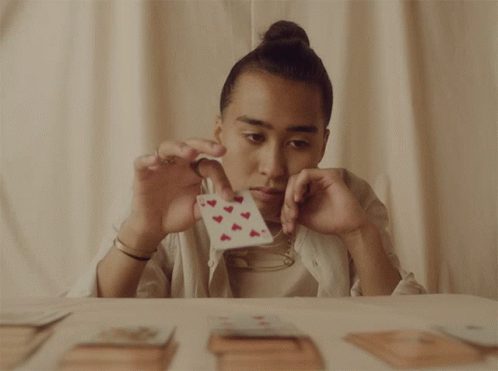 A Person Is Holding A Card With Hearts On It GIF
