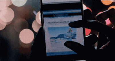 A Person Is Holding A Cell Phone With A Christmas Article On It GIF