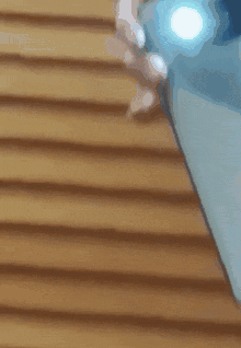 A Person Is Holding A Cell Phone With A Flashlight On It GIF