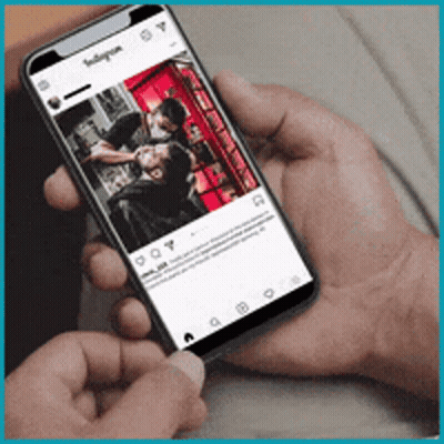 A Person Is Holding A Cell Phone With A Picture Of A Man Getting A Haircut On It GIF