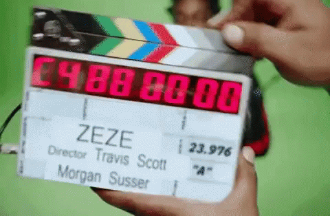 A Person Is Holding A Clapper Board That Says Zeze On It GIF