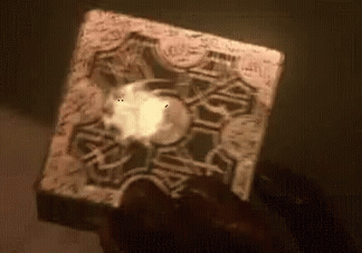 A Person Is Holding A Cube In Their Hand With A Glowing Light Inside Of It . GIF