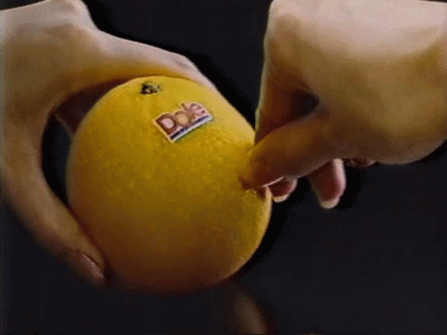 A Person Is Holding A Dole Orange In Their Hand GIF