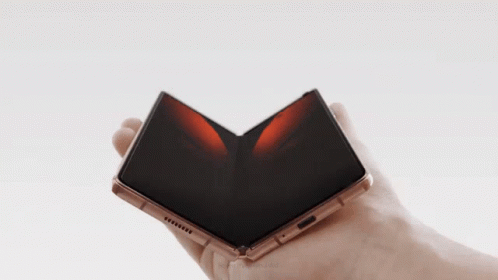 A Person Is Holding A Folded Phone In Their Right Hand GIF