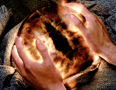 A Person Is Holding A Glowing Sphere In Their Hands GIF