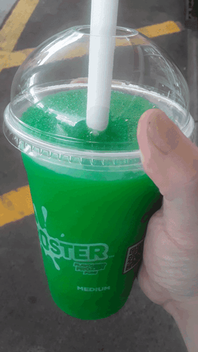 A Person Is Holding A Green Foster Drink With A White Straw GIF