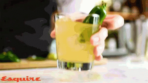 A Person Is Holding A Green Pepper In A Glass With Esquire Written On The Bottom Of The Image GIF