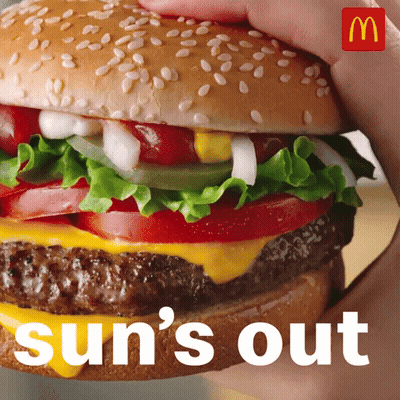 A Person Is Holding A Hamburger With The Words Sun 'S Out Behind Them GIF