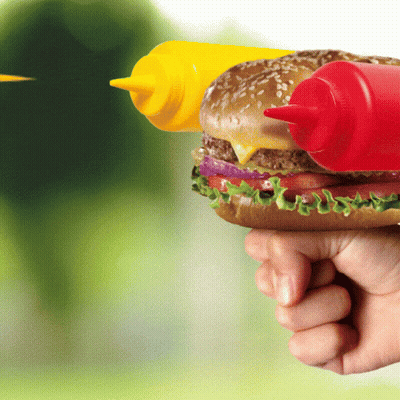 A Person Is Holding A Hamburger With Two Bottles Of Mustard And Ketchup GIF