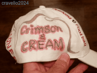A Person Is Holding A Hat That Says Crimson And Cream GIF