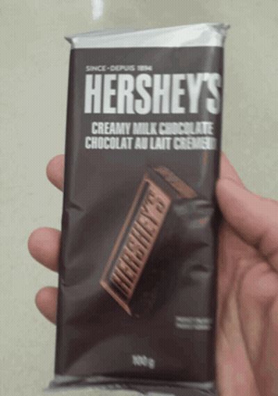 A Person Is Holding A Hershey 'S Bar In Their Hand GIF