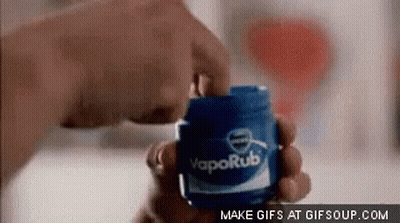 A Person Is Holding A Jar Of Vaporub . GIF