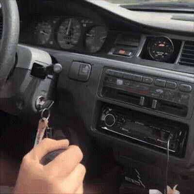 A Person Is Holding A Key In Their Hand In The Car GIF
