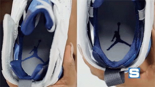A Person Is Holding A Pair Of Blue And White Nike Shoes GIF