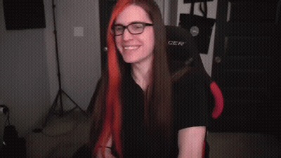 A Person Is Holding A Pair Of Scissors In Their Hands And Cutting A Piece Of Red Hair . GIF