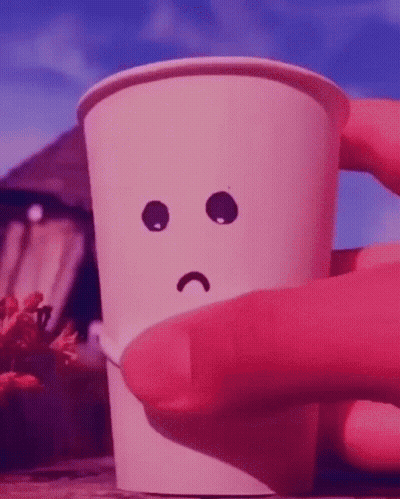A Person Is Holding A Paper Cup With A Sad Face Drawn On It GIF