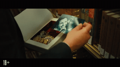 A Person Is Holding A Picture Of A Woman In A Box With The Number 18+ On The Bottom GIF