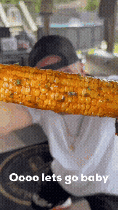 A Person Is Holding A Piece Of Corn On The Cob With The Words Oooo Lets Go Baby Below It GIF