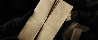 A Person Is Holding A Piece Of Paper In Their Hand GIF