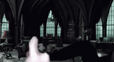 A Person Is Holding A Piece Of Paper In Their Hand In A Dark Room . GIF