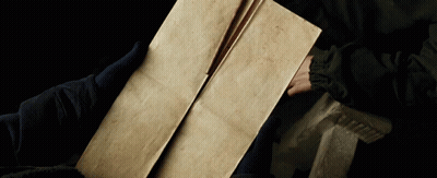 A Person Is Holding A Piece Of Paper That Is Very Old GIF