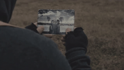 A Person Is Holding A Piece Of Paper With A Picture Of A House On It GIF