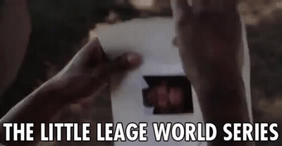 A Person Is Holding A Piece Of Paper With A Picture Of A Person On It . GIF