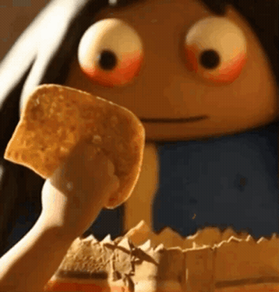 A Person Is Holding A Piece Of Tortilla Chips In Front Of A Cartoon Character With Big Eyes . GIF