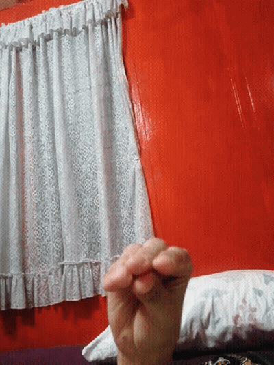 A Person Is Holding A Piece Of White Lace On A Red Table GIF