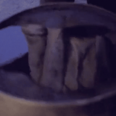 A Person Is Holding A Piece Of Wood In A Bucket Of Water . GIF