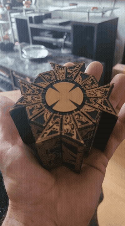 A Person Is Holding A Piece Of Wood With A Cross In The Center GIF