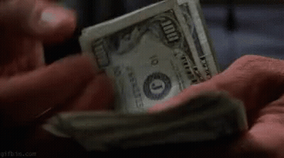A Person Is Holding A Pile Of Money In Their Hands . GIF