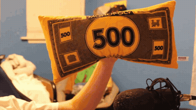 A Person Is Holding A Pillow That Looks Like A Monopoly Money GIF