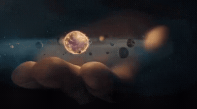 A Person Is Holding A Planet In Their Hand Surrounded By Other Planets . GIF