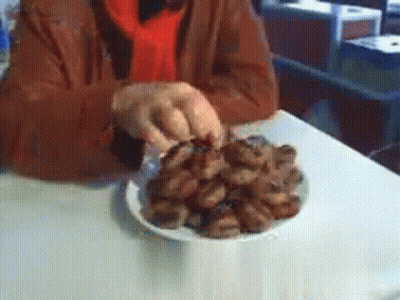 A Person Is Holding A Plate Of Food On A Table GIF