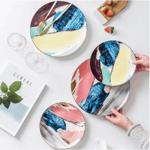 A Person Is Holding A Plate With A Fork On It . GIF