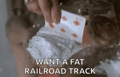 A Person Is Holding A Playing Card And A Bag Of Cocaine In Their Hand . GIF
