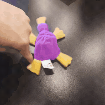A Person Is Holding A Purple And Yellow Stuffed Animal With A Tag That Says Mcdonalds On It GIF