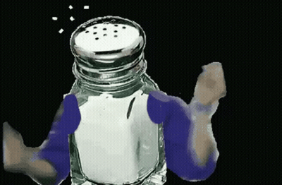 A Person Is Holding A Salt Shaker With Salt Coming Out Of The Top . GIF