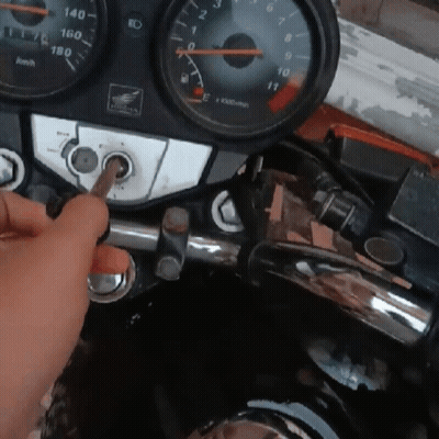 A Person Is Holding A Screwdriver In Front Of A Honda Dashboard GIF