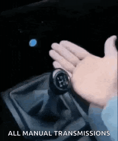 A Person Is Holding A Shifter In A Car And Pressing A Button . GIF