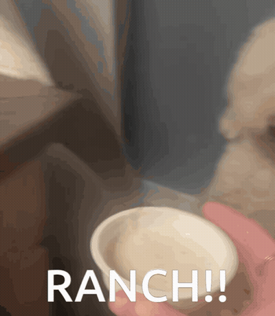 A Person Is Holding A Small Bowl Of Ranch Sauce GIF