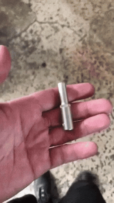 A Person Is Holding A Small Piece Of Metal In Their Hand . GIF
