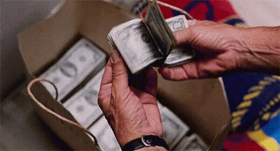 A Person Is Holding A Stack Of Money In Their Hands . GIF