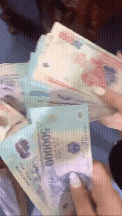 A Person Is Holding A Stack Of Money That Says 500000 On It GIF